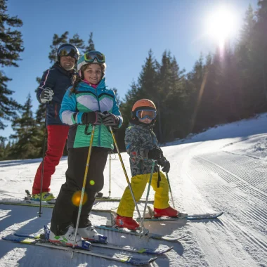 Famille skiant sur les pistes enneigées du Grand Puy