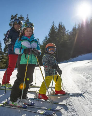 Famille skiant sur les pistes enneigées du Grand Puy